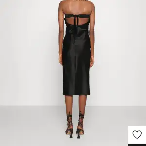 En svart bandaue klänning som är super fin i ryggen. Ny med prislapp, aldrig använd. Finns ej längre att köpa i butik. 