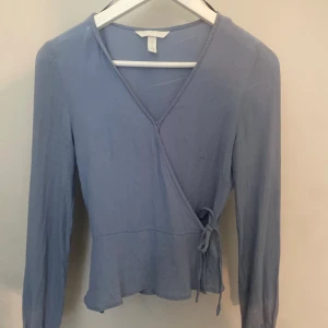 Blå blus  - Säljer denna blåa blusen med volang och knytte från H&M. 