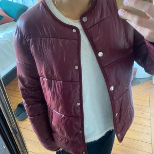 Vinröd vårjacka  - Vinröd tunn dunjacka perfekt nu till vår/sommar kvällar! Storlek m men passar även xs/s beroende hur man vill att den ska sitta. 