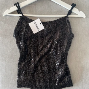 Festtopp svart glitter - Säljer denna fina festtopp från märket Steve Madden.  •Helt oanvänd •Storlek S / Small •Inköpt förra året innan nyår •Nypris 499 kr mitt pris 249 kr