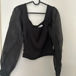 Blus - Blus i mycket bra skick. Skira, genomskinliga armar. Dragkedja i ryggen.