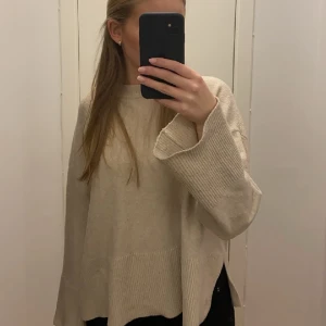 Stickad tröja med slits  - Säljer denna beiga stickade tröja med slits från bershka.