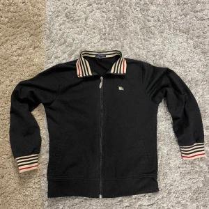 Burberry zip - Säljer min riktigt snygga burberry zip eftersom den inte passar mig. Har använt den ca 2 gånger så skicket på den är helt super! Den är storlek L men sitter som S/XS. Priset är inte hugget i sten.  
