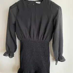Jättefin svart klänning från Kappahl. Storlek 152. Snygg smockad nederdel som sitter tajt. Tunna ärmar. Väldigt fint skick, endast använd några gånger.   Rök- & djurfritt hem. 