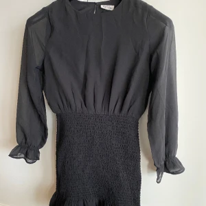 Svart snygg klänning tjej strlk 152 - Jättefin svart klänning från Kappahl. Storlek 152. Snygg smockad nederdel som sitter tajt. Tunna ärmar. Väldigt fint skick, endast använd några gånger.   Rök- & djurfritt hem. 