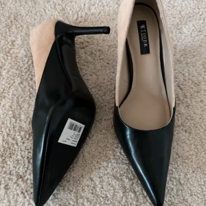 Tiger of Sweden pumps i svart läder och beige mocka strlk 39 - Oanvända Tiger of Sweden pumps i storlek 39 (små i storlek). Svart läder och beige mocka. 