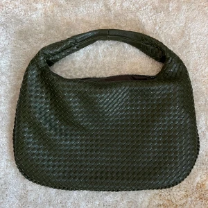 Grön stor vävd väska - Säljer denna jättefina populära väskan i mörkgrön, lik bottega veneta. Köpt från ett danskt märke för typ 800kr, använd 1 gång och i nyskick. Den stora modellen🫶🏼