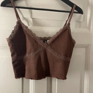 Brunt croppat linne  - Fint Ribbat brunt croppat linne med lite spets. Relativt bra använt men inget som syns. 