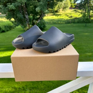 Yeezy Slide Onyx - Säljer ett par Yeezy Slide Onyx i storlek 43. Helt nya aldrig använda och original boxen finns kvar. Hör av dig för mer info eller frågor! Kan gå ner lite i pris vid en snabb och smidig affär