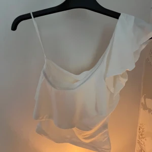 Enaxlad volang topp - Superfin volang topp med en arm från H&M, köptes för ett tag sedan men är aldrig använd, så i ny skick 💕