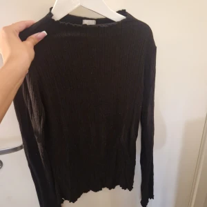 Svart tröja - Svart tunn tröja med lite coola "frill" detaljer vid alla kanter. Matrialet är lite randigt men inte direkt ribbat. Jätte strechig. Sticker ut lite trådar men inget som förstör tycker jag🤍