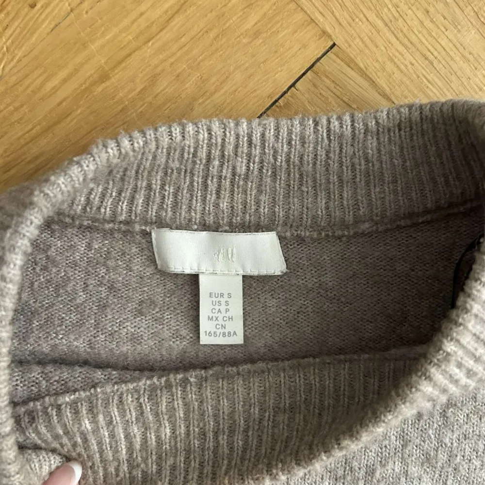 Säljer en beige stickad tröja som har tecken på användning (se bilderna).. Neuleet.