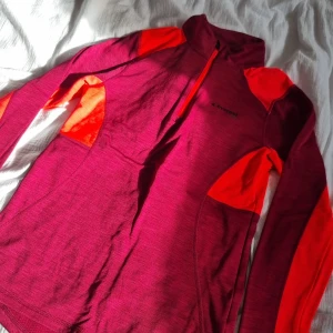 Tunnare utetröja  - En tunnare lila och rosa träningströja, med dragkedja upptill. 