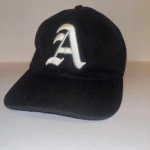 Cool svart keps - Bra material, spår av katt. Andvänd cirka 3-5 gånger.