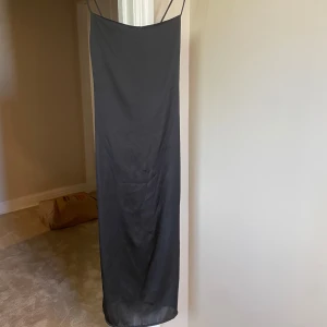 Satin klänning - Lång svart satin klänning med slit från pull & bear. Använd 1 gång, Kan skicka fler bilder vid intresse Köparen står för frakten