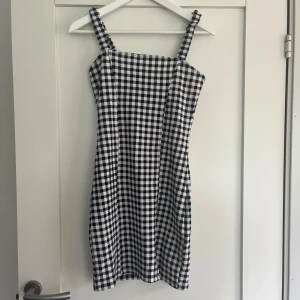 Rutig klänning  - Säljer denna svart-vit-rutiga kortklänningen från hm💖 Klänningen är i jättebra skick. Stretchigt material vilket gör att klänningen inte känns tajt. 