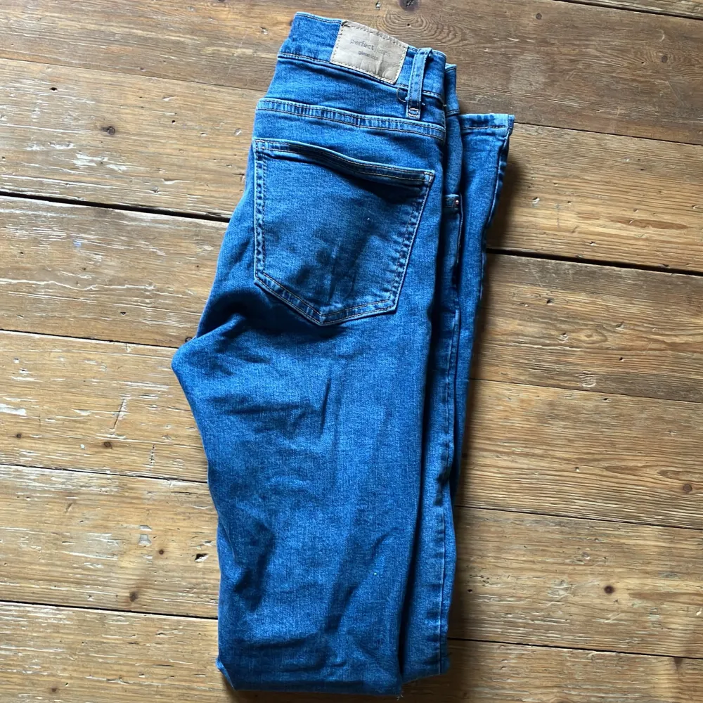 Ett par blå jeans från märket Perfect Jeans. Byxorna har en klassisk design med en dragkedja med knappstängning. De är i storlek 34 och har en normal passform. Använda men i mycket bra skick 9/10. Skicka dm vid frågor eller prisdiskussion.. Jeans & Byxor.