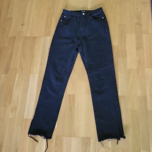 Svarta jeans - Svarta, högmidjade jeans från Missguided med en slits nedtill. Mycket bra skick! Säljer då jag inte använder dem längre. Nypris 515 kr.  (Pris kan diskuteras)