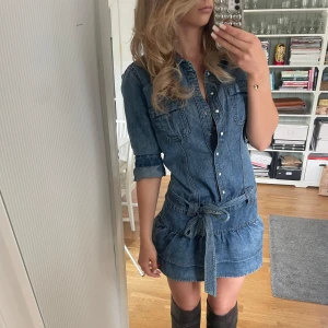 Jeansklänning - Världens finaste jeans klänning med skärp o volang nertill köpt second hand säljer då den är något stor för mig. Jag brukar ha xs-s, är 169 och har väldigt rak kroppsform. Denna är strl 38. Jättefint skick. Frakt tillkommer.