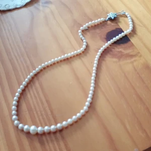 Pärlcollier med vita gula pärlor. - Vackert gammalt pärlcollier med vit gula pärlor och silverfärgade lås .