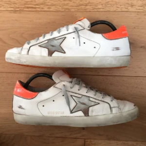 Golden Goose Superstar - Ett par feta golden goose skor med orange sula, de är storlek 42 men passar 43. Skick 8/10 med ”distressed” design skriv för frågor eller mer bilder.