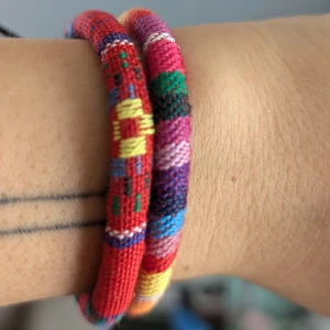 Färgglada Boho armband - Ett set av färgglada armband med olika mönster och färger. Armbanden är justerbara med svarta knytband. Aldrig använt 