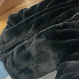 Svart Pälsjacka  - Svart pälsjacka från bubbelroom. Storlek 34. Superfint skick! Sitter som en kappa/aningen stor i storleken men funkar för xs-s.