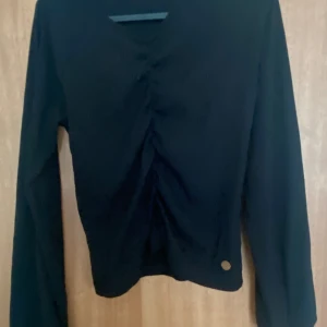 Svart Fin tröja - Svart långärmad tröja från Kappahl, inte använd så mycket. Detaljer på framsidan och puff armar. Skriv för fler bilder Storlek 158/164