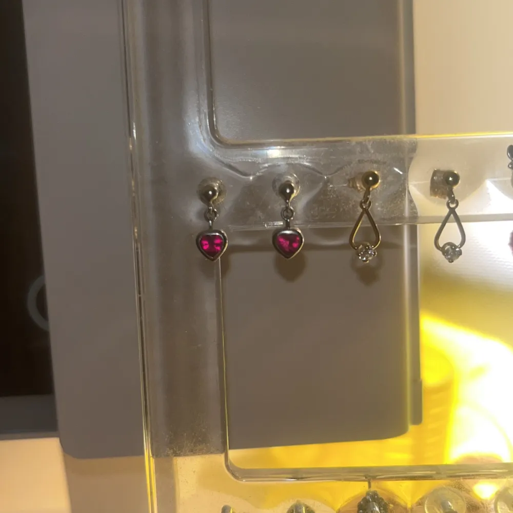 Rosa/röda hjärtörhängen. Äkta silver. Använda men bra skick. Lite tröga när man ska ta av stoppluppen, men det går. Vet inte vart de är ifrån. Säljer p.g.a används inte längre. Säljer ett par likadana fast i blå. Kolla min profil 🥰. Asusteet.