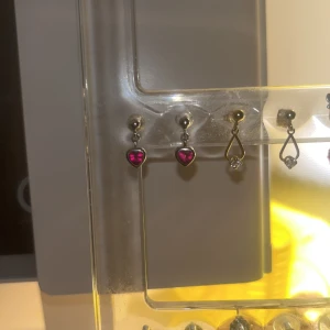 Rosa röda hjärtörhängen - Rosa/röda hjärtörhängen. Äkta silver. Använda men bra skick. Lite tröga när man ska ta av stoppluppen, men det går. Vet inte vart de är ifrån. Säljer p.g.a används inte längre. Säljer ett par likadana fast i blå. Kolla min profil 🥰