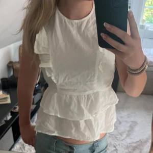 Vit blus med volanger - En vit blus med volanger, säljs då den inte kommer till användning