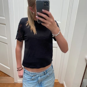 Svart tröja  - Jättefin svart tröja med spetts armar som inte säljs längre!! Inte super använd och ät i bra skick. Skriv för prisförslag och funderingar!!🥰🥰