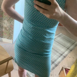 Blommig klänning från Malva - Supersnygg vintage ärmlös klänning från Malva i storlek S. Klänningen är blå med ett blommigt mönster och är tillverkad av 100% bomull. Den har en tight passform och är en kortklänning.  Varan kan skickas eller hämtas i Umeå🔆