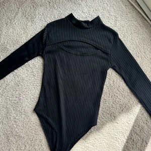 Svart body  - Svart body med en liten urringning.  Stl XS. 