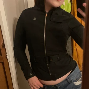 Snygg tight svart jacka - En skitsnygg svart tight jacka. Storlek XS. Med ett fint bälte i midjan. Väldigt formgivande, passar supersnyggt. För liten för mig så har svårt att ta fler bilder.