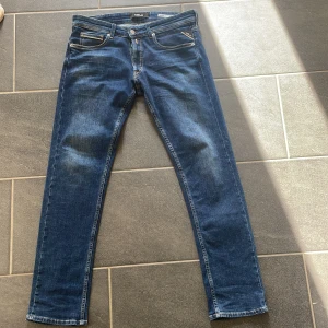 Blå jeansbyxor från Replay - Ett par blå jeansbyxor från Replay i modellen Grover. Byxorna har en straight fit och är i storlek 32. De har klassisk femficksdesign och är tillverkade i jeansmaterial. Pris går att diskutera vid snabb affär