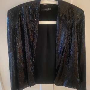 Svart paljettjacka från Atmosphere - fin svart paljettjacka från Atmosphere. Jackan har långa ärmar och är täckt med glittrande paljetter, perfekt för festliga tillfällen. Aldrig använt💕🌸