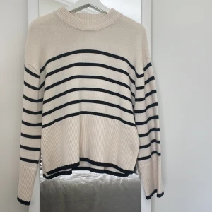 Randig fin tröja - En vit-svart randig tröja med slits vid höften/midjan. Knappt använd men stor i storlek. Medel hög hals.