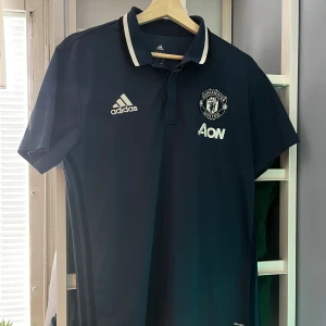 Manchester United Fotbollströja - Riktigt snygg United tröja i perfekt skick, tränings-piké från säsongen 16/17. Passar riktigt bra under sommaren till ett par linnebyxor eller för ett United-fan som vill ha en retrotröja!