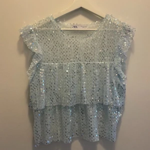 Turkos blus - Turkos glittrig topp med paljetter från zara. Finns inte att få tag på längre. Använd Max några gånger och är i jättebra skick men säljer då den inte kommer till användning passar s och xs