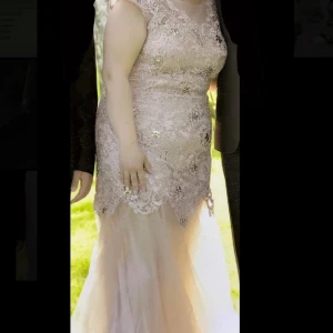 Klänning  - Lång beige festklänning i storleken 44.  Använd två gånger.   Pris: 1800  Skicka meddelande om du vill ha flera bilder på klänningen. Kan mötas i Södertälje eller så kan den fraktas.