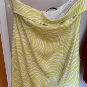 Säljer en grön vit klännig från Gina tricot i storlek M. Den är andvänd en gång. Med dragkedja på ryggen och en liten slits på sidan