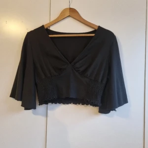 Sör svart topp - Säljer denna söta topp med vida ärmar💓 Köpt på plick, men i bra skick. Säljer då den inte kommit till användning. Finns ingen lapp så kan inte se storlek men skulle säga att den passar S/M/L, då den är väldigt stretchig. Säljer för 75kr + frakt💓