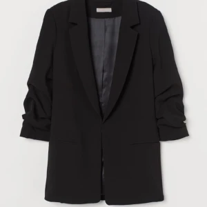 Kavaj med rynkad trekvartsärm - Lång och rak modell. Inga knappar, fodrad. Loose fit, normal i storleken.  Använd med försiktighet några gånger men i bra skick! Steamad.