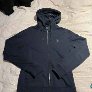 GANT ZIP HOODIE (NAVY) - Size S Nypris 1400kr Clean zip hoodie från Gant, inga flaws på den men den är måttligt använd, därav så släpper jag den för så billig peng jag kan.