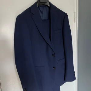 Kostym  - Riley kostym. Den har använts endast en gång. Kavaj, kostymbyxor och en slips.  Passar dig som är ca 170-178