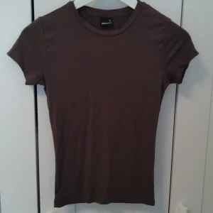 Gina Tricot t-shirt - Superskön mörkgrå t-shirt med stretchigt material, använd endast en gång🤍 Färgen på sista bilden ser lite annorlunda ut jämfört med första men det är bara olika ljus på bilderna!💕