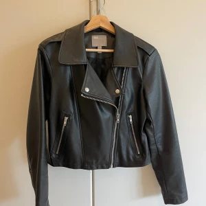 Skinnjacka - Midjekort jacka i konstgjort skinn från Asos. Mycket sparsamt använt och i fint skick. Normal i storleken.