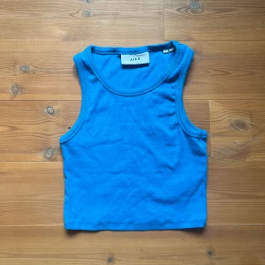 ribbat linne - Kort linne i ribbat tyg och en supervacker klarblå färg köpt från Zalando för något år sedan. Helt oanvänd och inga synliga defekter, materialet är kvalitativt och lite tjockare. Sitter tajt!