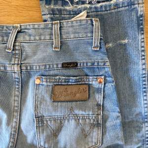 Ljusblåa jeans från Wrangler i storlek 36, lösa och raka i benen